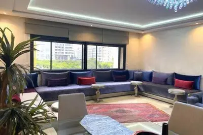 a living room with a blue couch with red pillows at Familial Boulevard D Anfa - By AppartAli in Casablanca