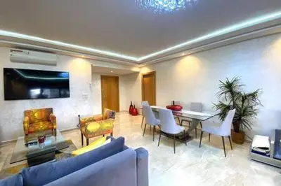 a living room with a couch and a table and chairs at Familial Boulevard D Anfa - By AppartAli in Casablanca