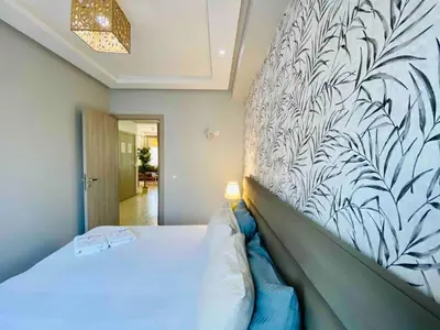 a bedroom with a large bed with a wall at Sunny OASIS 2 Bedrooms - By AppartAli in Casablanca