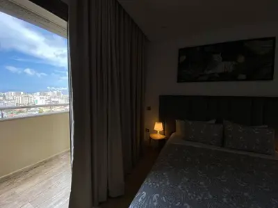 a bedroom with a bed and a large window at Maarif City Sunrise- 3 Beds - By AppartAli in Casablanca