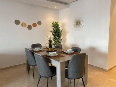 a dining room with a wooden table and chairs at Maarif Top Floor - 2 Bedrooms - By AppartAli in Casablanca