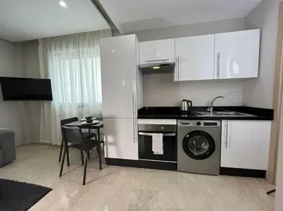 a kitchen with a washing machine and a table at Modern Cosy Studio Anfa in Casablanca