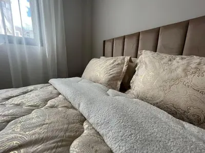 a bed with white blankets and pillows next to a window at Modern Cosy Studio Anfa in Casablanca