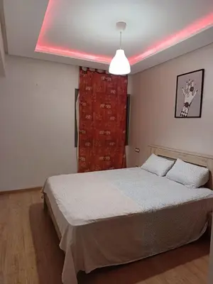 a bedroom with a bed with a pink light at Apartment kamal park E21 in Mohammedia