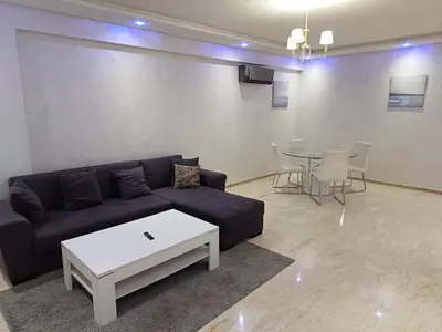 a living room with a couch and a table at Apartment kamal park E21 in Mohammedia