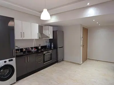 a kitchen with a black refrigerator and a washer at Apartment kamal park E21 in Mohammedia