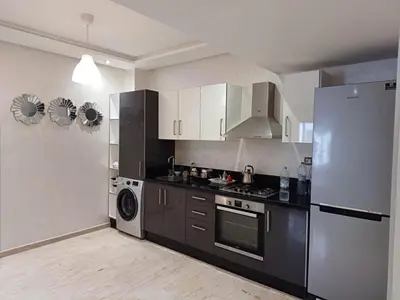 a kitchen with a refrigerator and a stove at Apartment kamal park E21 in Mohammedia