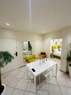 a living room with a white table and a couch at SUITOUISS - Océan 1 - Appartement centre ville au front de mer in Rabat