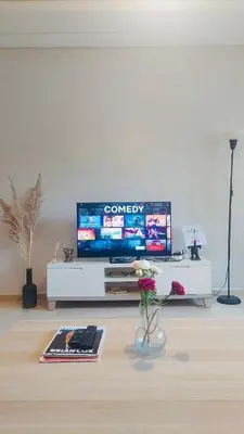 a living room with a television on a white entertainment center at Chic & cosy Flat Near Airport lockbox fast wifi in Nouaceur
