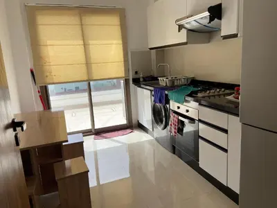 a small kitchen with a stove and a window at Beaulieu du Park commode et paisible in Mohammedia