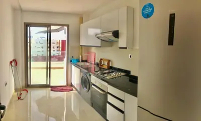 a kitchen with a stove and a washer and dryer at Beaulieu du Park commode et paisible in Mohammedia
