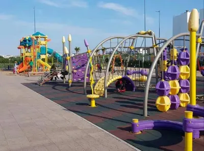 a playground with slides and rides in a park at Grand Apartement a Blanca Beach Sidi Rehal in Sidi Rahal