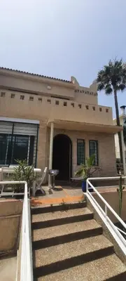 a house with stairs in front of it at Les Portes de l'Océan avec piscine uniquement l'été in El Harhoura