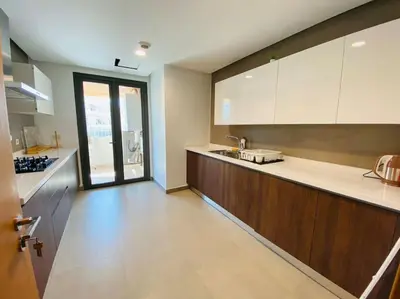 a kitchen with white cabinets and a counter top at Marina - Sea & Mosque View - By AppartAli in Casablanca