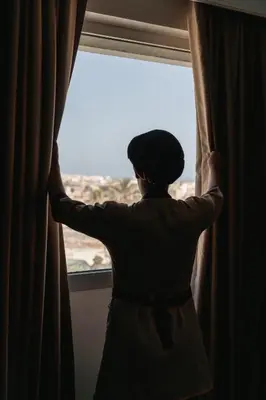 a person is looking out of a window at Kenzi Basma in Casablanca
