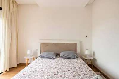 a bedroom with a large bed with two tables at Lovely Appartement Prestigia Hayriad in Rabat