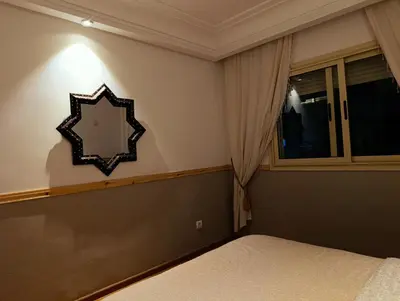 a bedroom with a bed and a mirror on the wall at Appartement de Charme Avec Vue Sur Mer in Casablanca