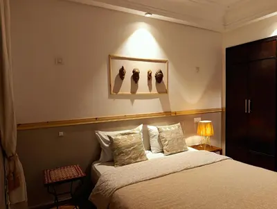 a bedroom with a bed and a lamp on a wall at Appartement de Charme Avec Vue Sur Mer in Casablanca
