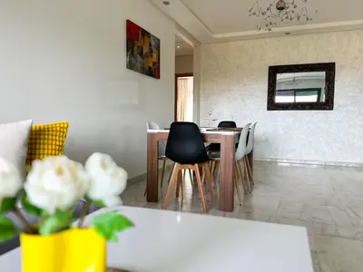 a dining room with a table and chairs at luxe appartement met zeezicht en zwembad Mohammedia Parc in Mohammedia