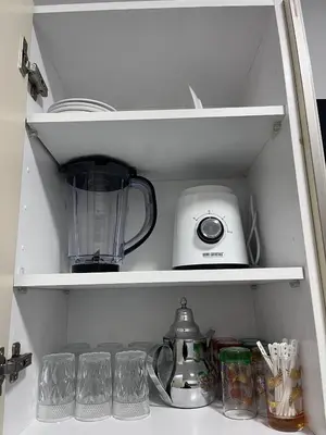 a kitchen shelf with a blender and other kitchen items at luxe appartement met zeezicht en zwembad Mohammedia Parc in Mohammedia