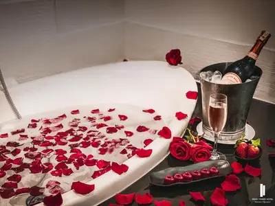 a table with a cake with red roses and a bottle of champagne at Kenzi Tower Hotel in Casablanca