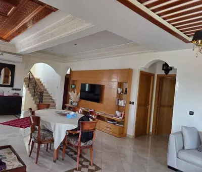 a living room with a table and chairs and a couch at Instant Saisons - Ferme d'hôtes in Skhirat