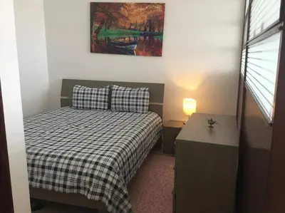 a small bedroom with a bed and a table at Amazing view overlooking the ocean and Hassan 2 in Casablanca