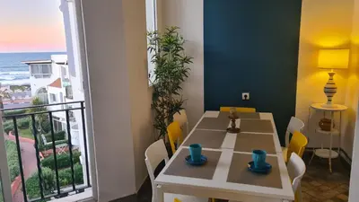 a dining room with a table and a view of the ocean at Océan Beach in Tamaris
