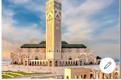 a large building with a clock tower in front of it at Splendid appartament a 3 Min de la mer et de la mosquée hassan 2 in Casablanca