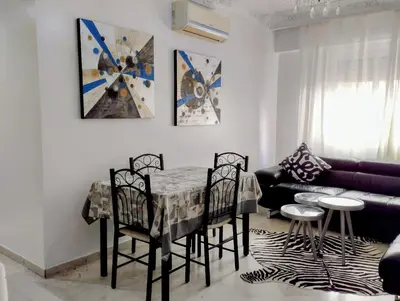 a living room with a table and chairs and a couch at Splendid appartament a 3 Min de la mer et de la mosquée hassan 2 in Casablanca