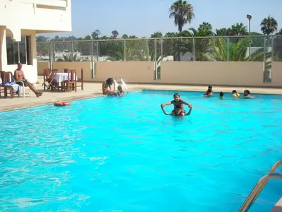 a group of people swimming in a swimming pool at Hotel Suisse in Casablanca