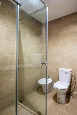 a bathroom with a toilet and a glass shower stall at Arribat Center Mall- TT Holidays Agdal in Rabat