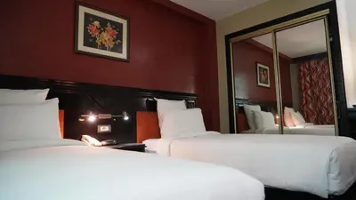 a hotel room with two beds and a mirror at Hotel Toubkal in Casablanca
