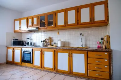 a kitchen with wooden cabinets and a stove at Sunset escape by the sea in Temara