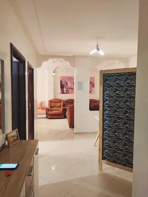a living room with a couch and a table in a room at Appartement propre et bien équipé à Ain sebaa in Casablanca