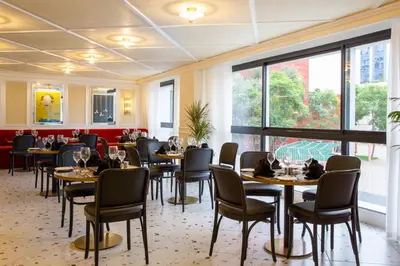 a dining room with tables and chairs and windows at Best Western Plus Casablanca City Center in Casablanca