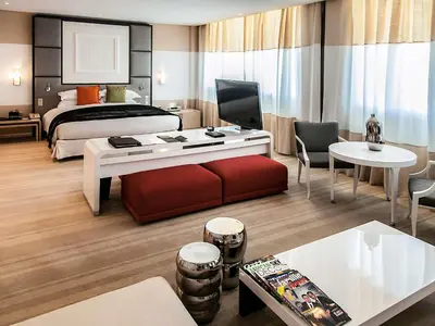 a hotel room with a bed and a living room at Sofitel Rabat Jardin Des Roses in Rabat