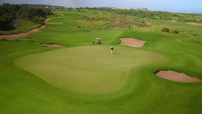 a golfer is playing on a green golf course at Mazagan Beach & Golf Resort in El Jadida