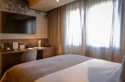 a bedroom with a bed with a television and a window at Villa Blanca Urban Hotel in Casablanca