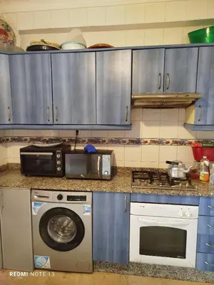 a kitchen with a microwave and a washing machine at appartement au bord de l'eau in Mohammedia