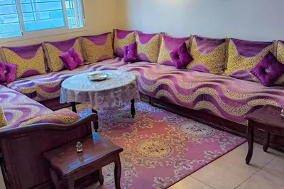 a purple couch in a living room with tables at joli appartement près de la mer in Casablanca