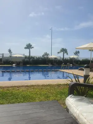 a swimming pool with a bench and a playground at HEAVEN BEACH in Sidi Rahal
