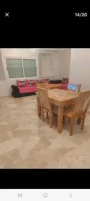 a dining room with a wooden table and chairs at Appartement avec piscine proche de la plage in Mohammedia