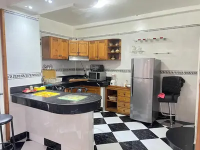 a kitchen with a black and white checkered floor at Housse F2 famille in Rabat