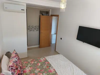a bedroom with a bed and a flat screen tv on a wall at BLANCA BEACH Sidi Rahal Front Mer in Sidi Rahal