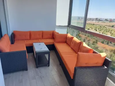 a living room with an orange couch and a table at BLANCA BEACH Sidi Rahal Front Mer in Sidi Rahal
