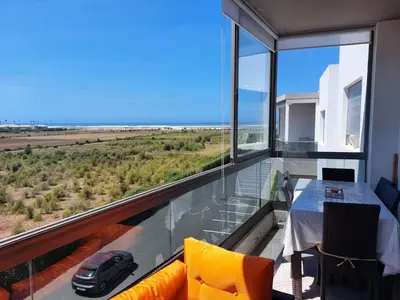 a room with a view of a car on a balcony at BLANCA BEACH Sidi Rahal Front Mer in Sidi Rahal