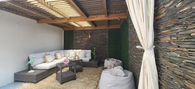 a living room with a couch and a stone wall at L'Amouage Casablanca Location Journalière Casablanca in Casablanca